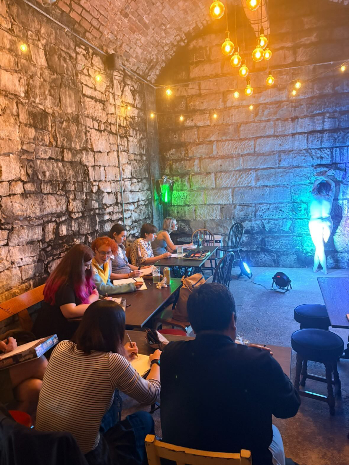 A warm, lamp-lit life drawing session